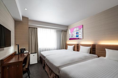 a hotel room with two beds and a desk at Noku Osaka in Osaka