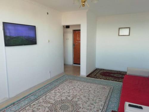 Il comprend un salon doté de murs blancs et d'une télévision à écran plat. dans l'établissement 3 дом вид на море, à Aktau