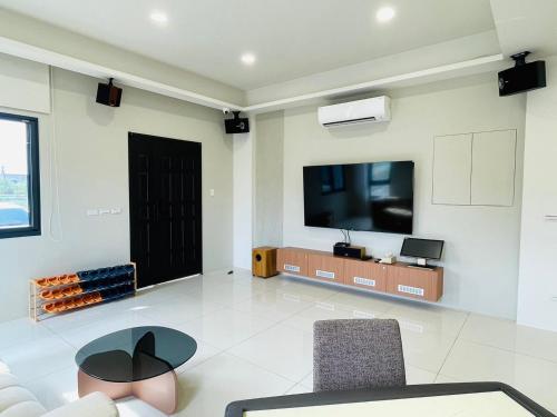 a living room with a tv and a table and chairs at Tian Central Light Brigade in Wujie
