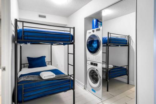 een slaapkamer met een stapelbed en een wasmachine bij One Bed and Den Upscale Comfort Condo with Parking in Toronto