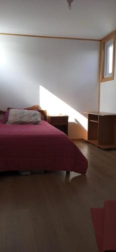 een slaapkamer met een rood bed en een raam bij Pieza Labranza 