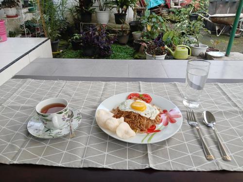 Un plato de comida en una mesa con una taza de café. en Bungo Bed & Breakfast Workation, en Bukittinggi