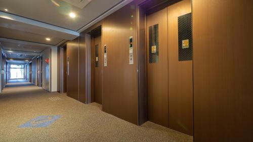 a hallway with wooden doors in a building at Toyoko Inn Osaka Yodoyabashi-eki Minami in Osaka