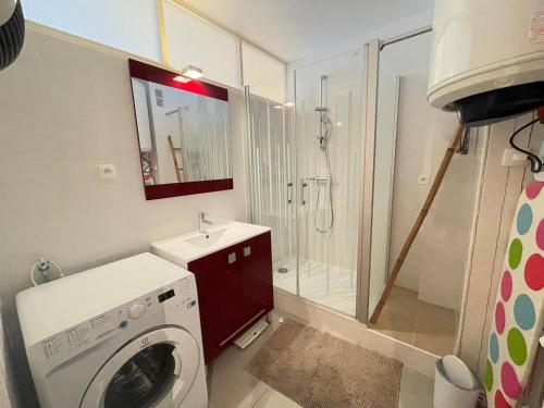 une salle de bain avec une machine à laver et un lavabo dans l'établissement Bel appartement 1 chambre tout confort au bord de la mer avec balcon et parking - FR-1-323-216, à Saint-Jean-de-Monts