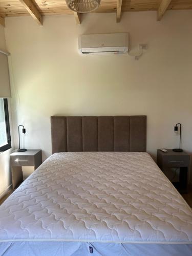 a bedroom with a large white bed in a room at Sombras del Pinar in Necochea