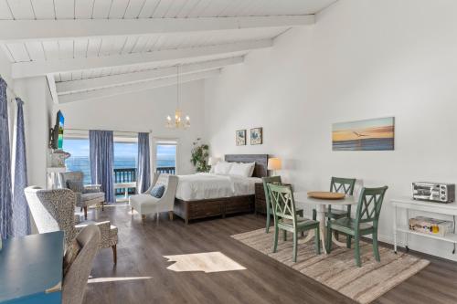 a bedroom and living room with a bed and a table at Romantic Getaway - Luxury Oceanfront Studio - Private Balcony - Fireplace in Oceanside