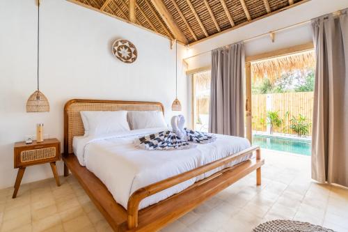 1 dormitorio con cama y piscina en Villa Kelapa Kucing, en Gili Air