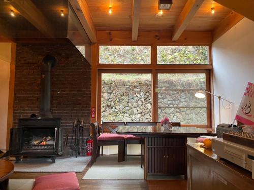 a living room with a fireplace and a stove at Guest House Eleven Village Fukiya in Fukiya
