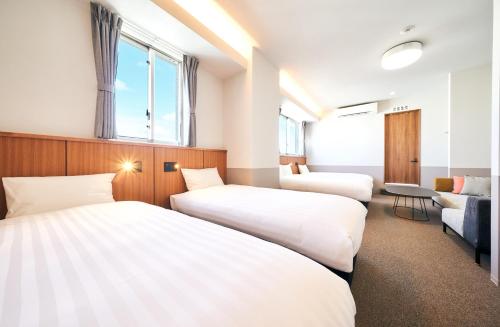 a hotel room with two beds and a couch at Rakuten STAY Naha Yachimun Street in Naha