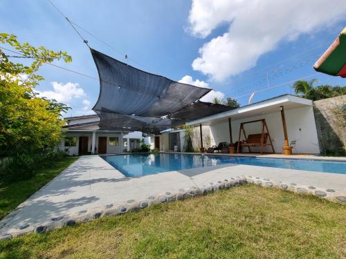 a large umbrella over a swimming pool in a house at CMJ Private Resort 