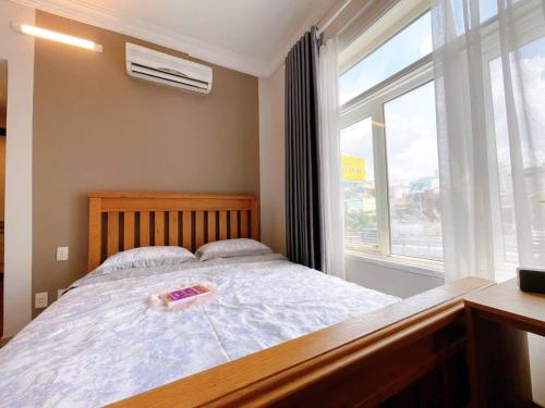 a bedroom with a large bed with a window at SONGMAX.HOME in Ho Chi Minh City