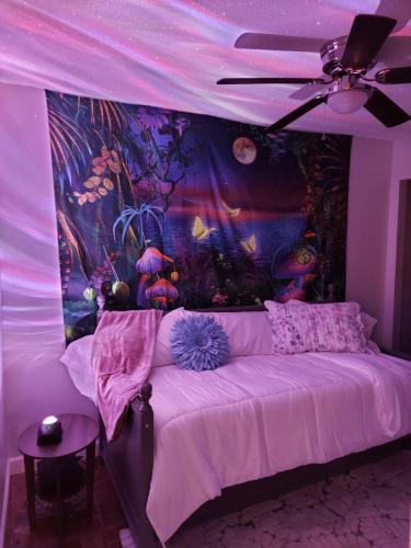 Habitación púrpura con cama con pintura en la pared en PEACE WATER INN, en Gautier