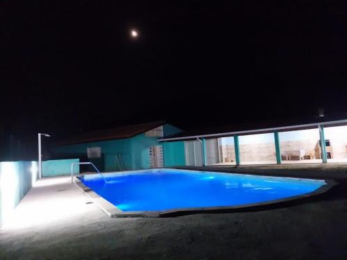 uma grande piscina azul à noite em Casa de campo Maciel em Joanópolis