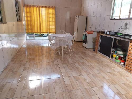 um quarto com uma mesa e uma cozinha com uma mesa e frigorífico em Casa de campo Maciel em Joanópolis