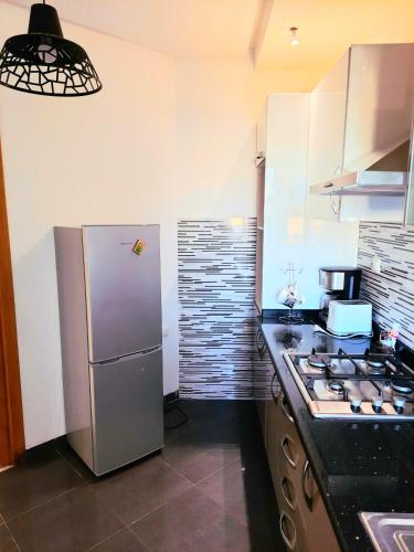 a kitchen with a stainless steel refrigerator and a stove at Les jardins du lac 2 in Tunis