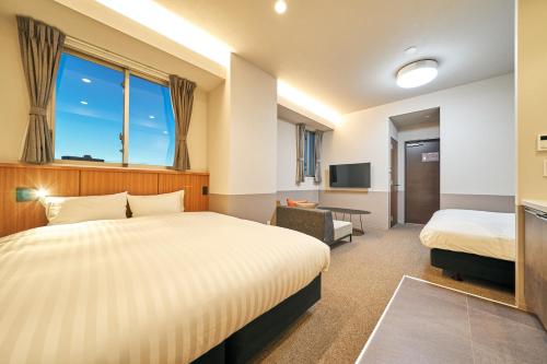 a hotel room with two beds and a television at Rakuten STAY Naha Yachimun Street in Naha