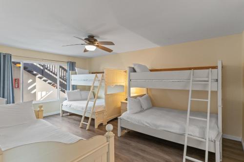a room with two bunk beds and a ceiling fan at Oceanfront Family Getaway - BBQ - Oceanfront Seating in Oceanside