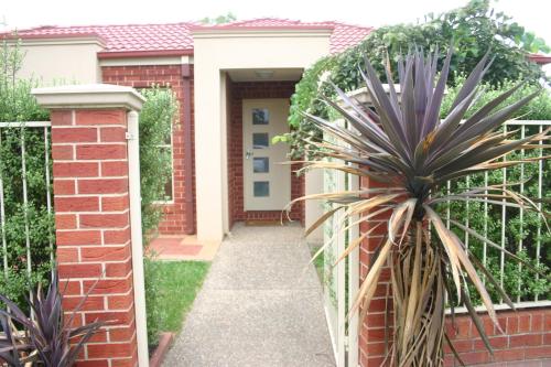 a fence in front of a house with a plant at Villa on Nathan in Albury