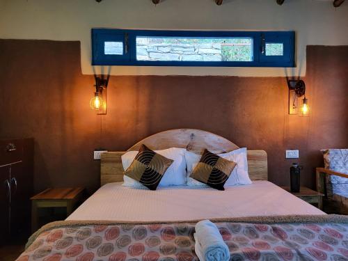 a bedroom with a bed with a window above it at Zenoaks Homestay in Almora