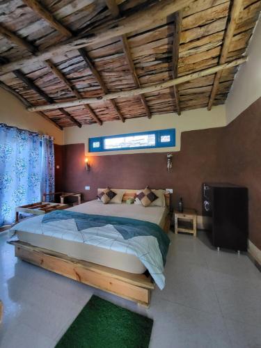 a bedroom with a large bed and a television at Zenoaks Homestay in Almora