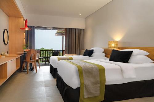 two beds in a hotel room with a balcony at Novus Giri Resort & Spa in Puncak