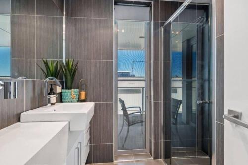 La salle de bains est pourvue d'un lavabo et d'une douche en verre. dans l'établissement Terrace Breeze, à Ocean Grove