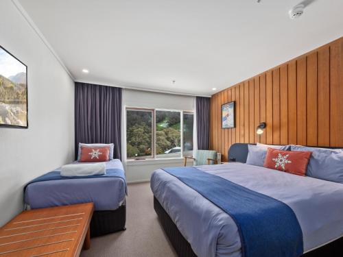 a hotel room with two beds and a window at Thredbo Alpine Hotel in Thredbo