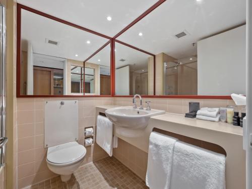 a bathroom with a toilet and a sink at Thredbo Alpine Hotel in Thredbo