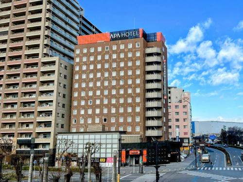 un grande edificio con un nuovo segno di speranza di APA Hotel Chiba Yachiyo Midorigaoka a Yachiyo