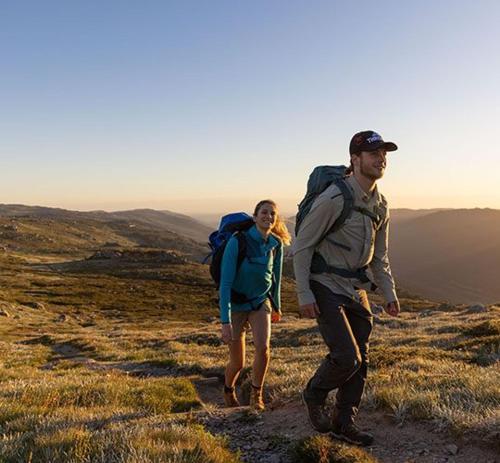 a man and a woman walking on a mountain at Thredbo Alpine Hotel in Thredbo
