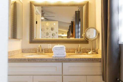 a bathroom with a sink with a mirror and towels at Ohana’s Home in Chula Vista