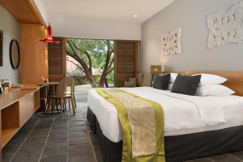 a bedroom with a large bed and a kitchen at Novus Giri Resort & Spa in Puncak