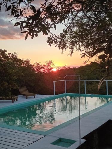 una piscina con puesta de sol en el fondo en Orquídeas en Quebrada de los Pozos