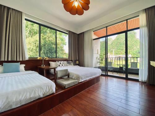um quarto com uma cama e uma cadeira e janelas amplas em 林涧小栈Linger house em Yangshuo