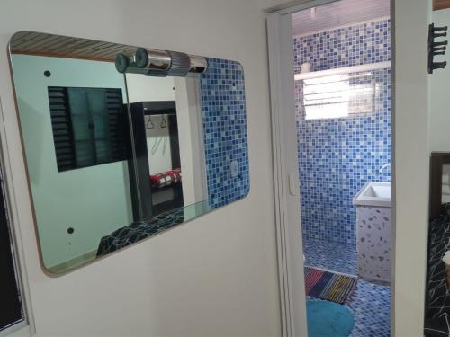 a mirror in a bathroom with blue tiles at Cantinho da Saudade in Campos do Jordão