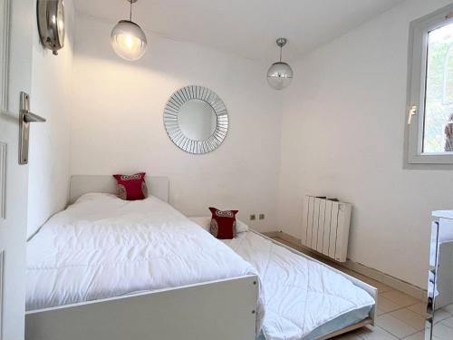 een slaapkamer met een wit bed en een spiegel bij Appartement Le Lavandou, 3 pièces, 4 personnes - FR-1-251-529 in Le Lavandou