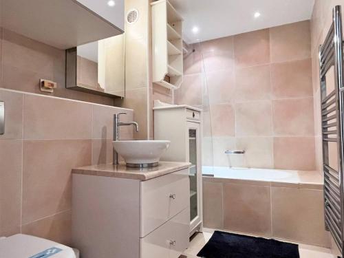 une salle de bain avec un lavabo, des toilettes et une baignoire dans l'établissement Duplex climatisé avec piscine, terrasse et parking - 6 couchages - Le Lavandou - FR-1-251-529, au Lavandou
