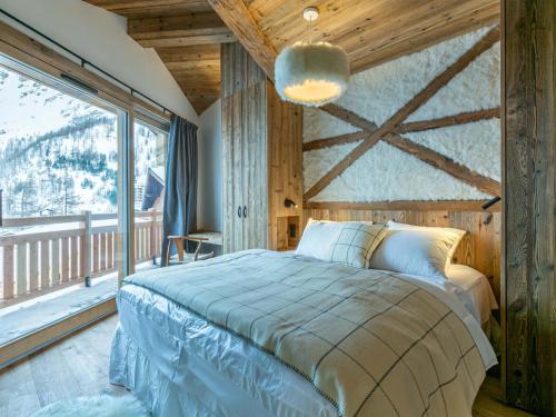 une chambre avec un lit et une grande fenêtre dans l'établissement Chalet de luxe lumineux avec panorama, WIFI, garage, balcons et services haut de gamme, Val-d'Isère - FR-1-694-344, à Val dʼIsère