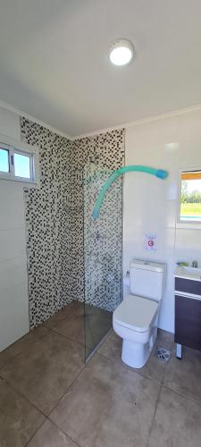 een badkamer met een toilet en een glazen douche bij Casa de campo El Olam in San Miguel del Monte