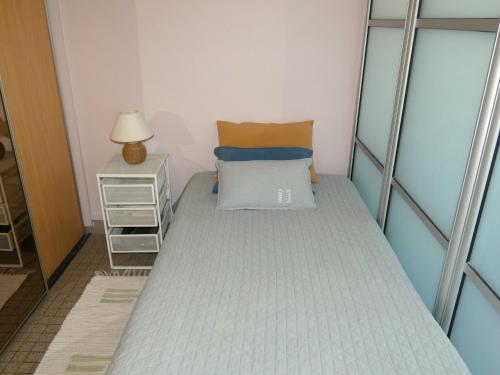 une petite chambre avec un lit et une table de chevet dans l'établissement Appartement 1 chambre avec TV, Wi-Fi, animaux admis - FR-1-323-412, à Saint-Jean-de-Monts