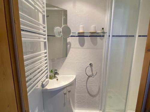 La salle de bains blanche est pourvue d'une douche et d'un lavabo. dans l'établissement Studio Les Arcs 1800, 1 pièce, 2 personnes - FR-1-411-931, à Bourg-Saint-Maurice