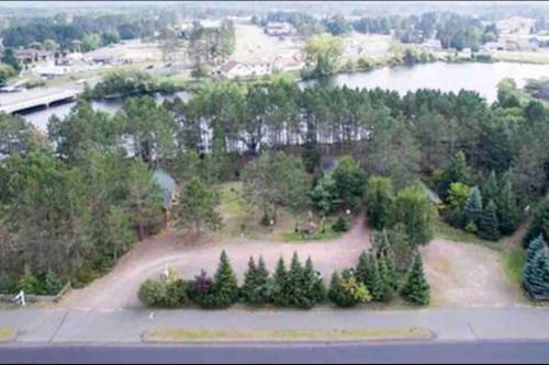 an aerial view of a park with trees and a lake at Fancy Fireflies Cabin in Hayward