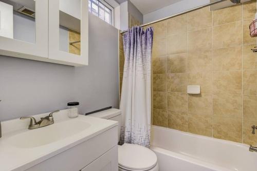 a bathroom with a toilet and a sink and a shower at Spacious Suite in Deanwood + Free Parking in Washington, D.C.