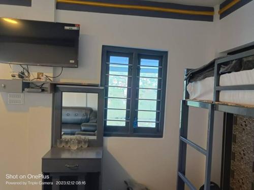 a room with a tv and a bunk bed at Sruthi Garden. Homestay. Kodaikanal in Kodaikānāl