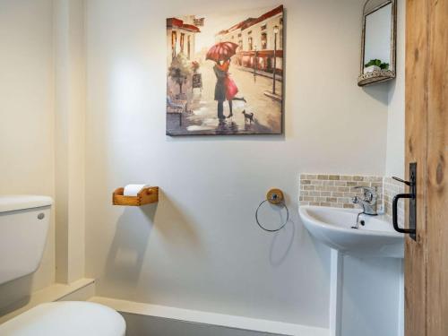 a bathroom with a picture of a woman with an umbrella at 2 Bed in Wasdale SZ436 in Santon Bridge