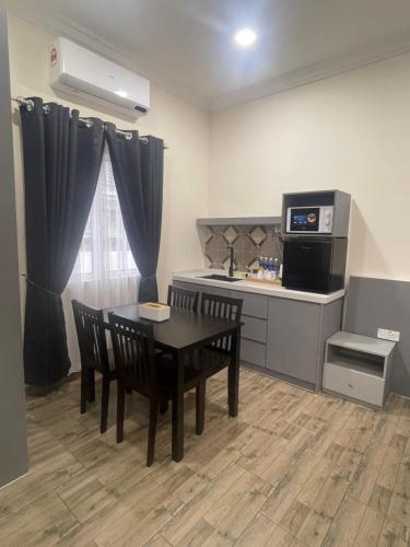 uma cozinha com mesa e cadeiras num quarto em D'Laman Cottage Kota Bharu kelantan em Kota Bharu