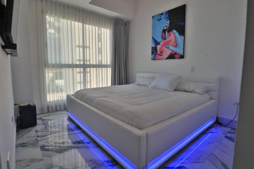 a white bedroom with a bed with blue lights at Guest Friendly Cartagena 2BR Jacuzzi stripper pole in Cartagena de Indias