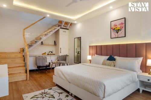 1 dormitorio con 1 cama grande y una escalera en StayVista at SilverSpring Cottage with Valley View & Bonfire en Dehradun