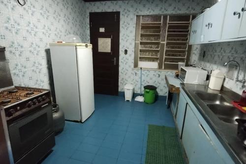 a kitchen with a white refrigerator and a sink at Moka Refúgium - Uma bela e espaçosa a 200m da praia in Belém