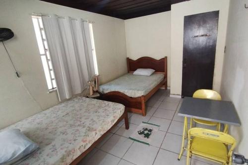 a room with two beds and a table and chairs at Moka Refúgium - Uma bela e espaçosa a 200m da praia in Belém